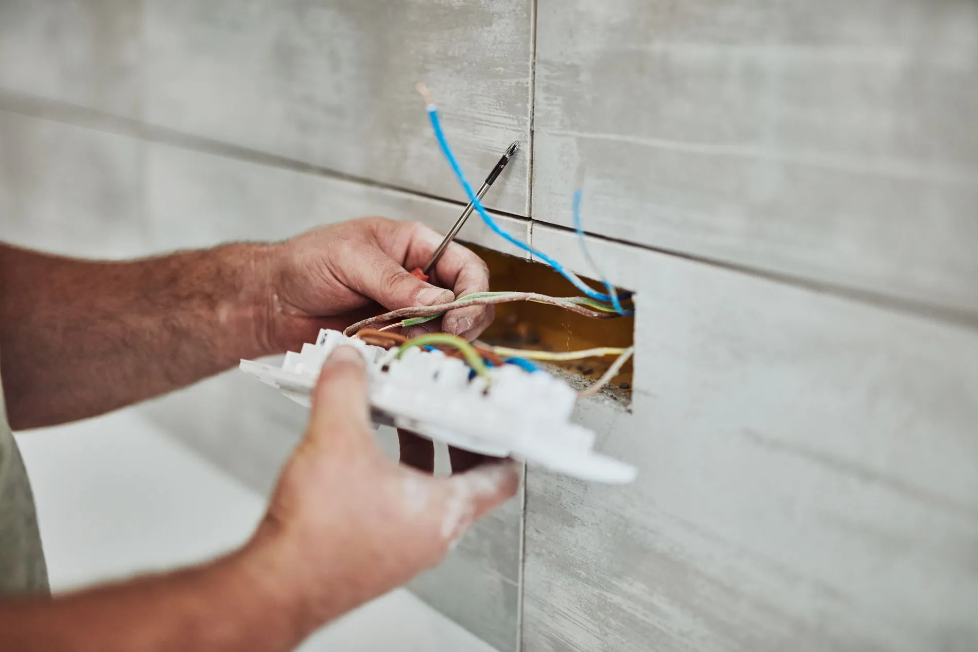 adobe_271728531 - Electrician repairing / fixing wires in the wall.